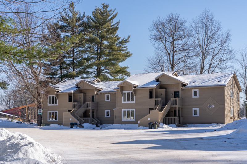 Snow‑covered condominium building at Telemark Northwoods Lodging during winter in Cable, Wisconsin.